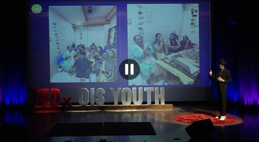 Kaabir Jaisingh speaking on stage at TEDxYouth@OIS